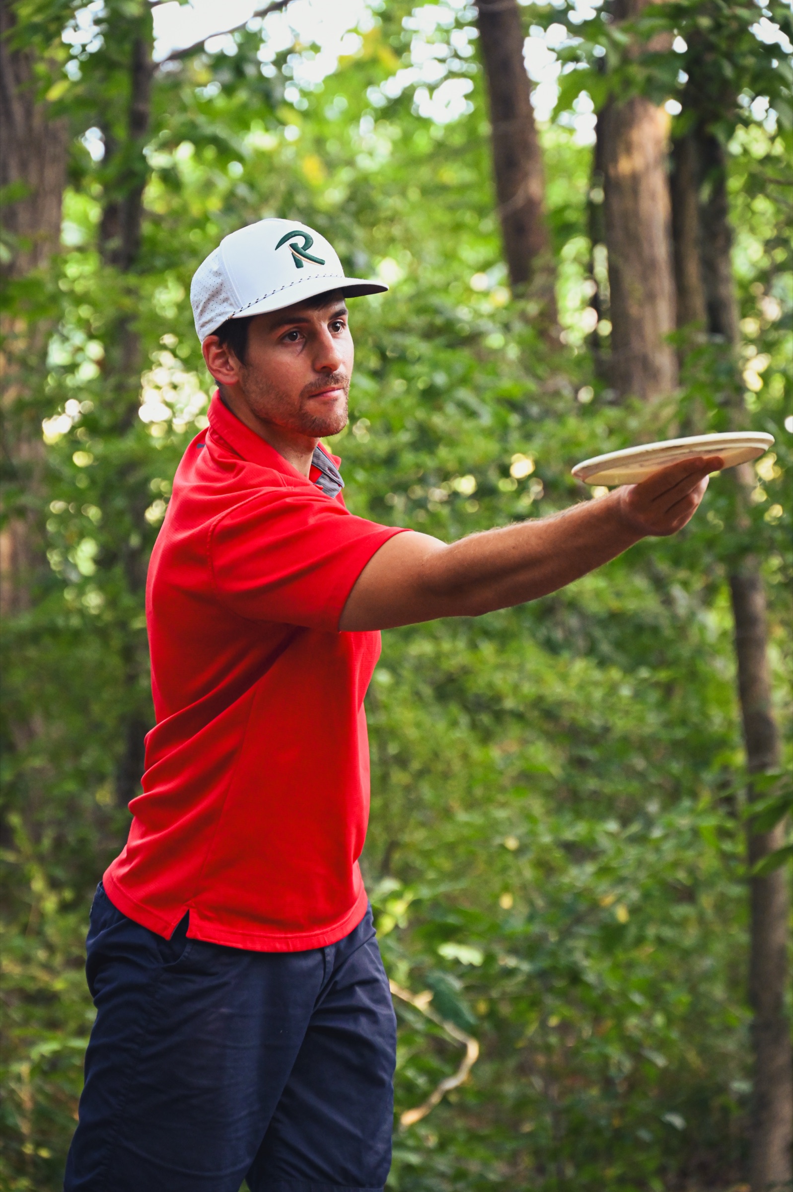 A player in a Radius cap lining up the shot, disc out in front