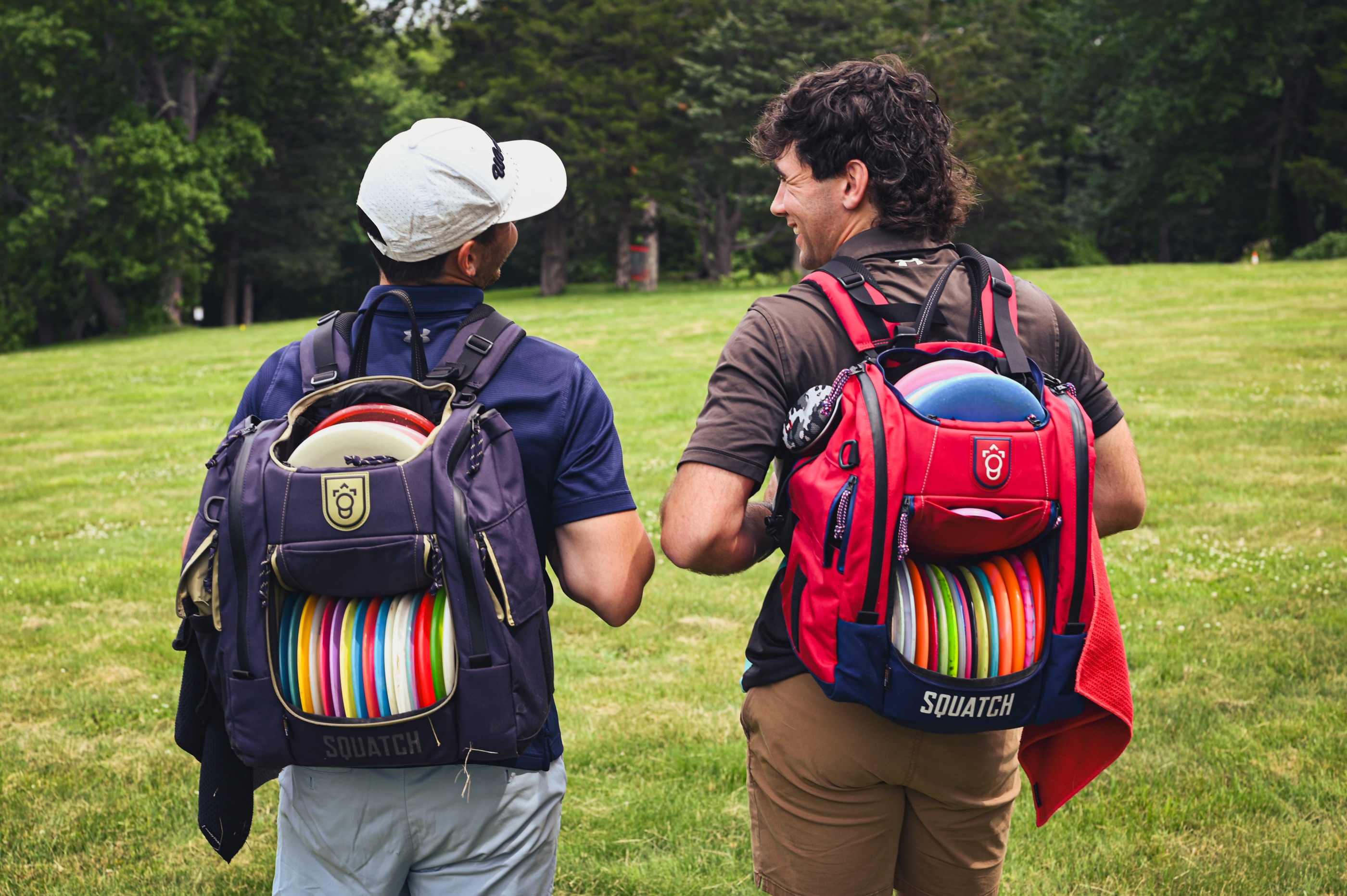 Two players walking down the fairway, Squatch bags on