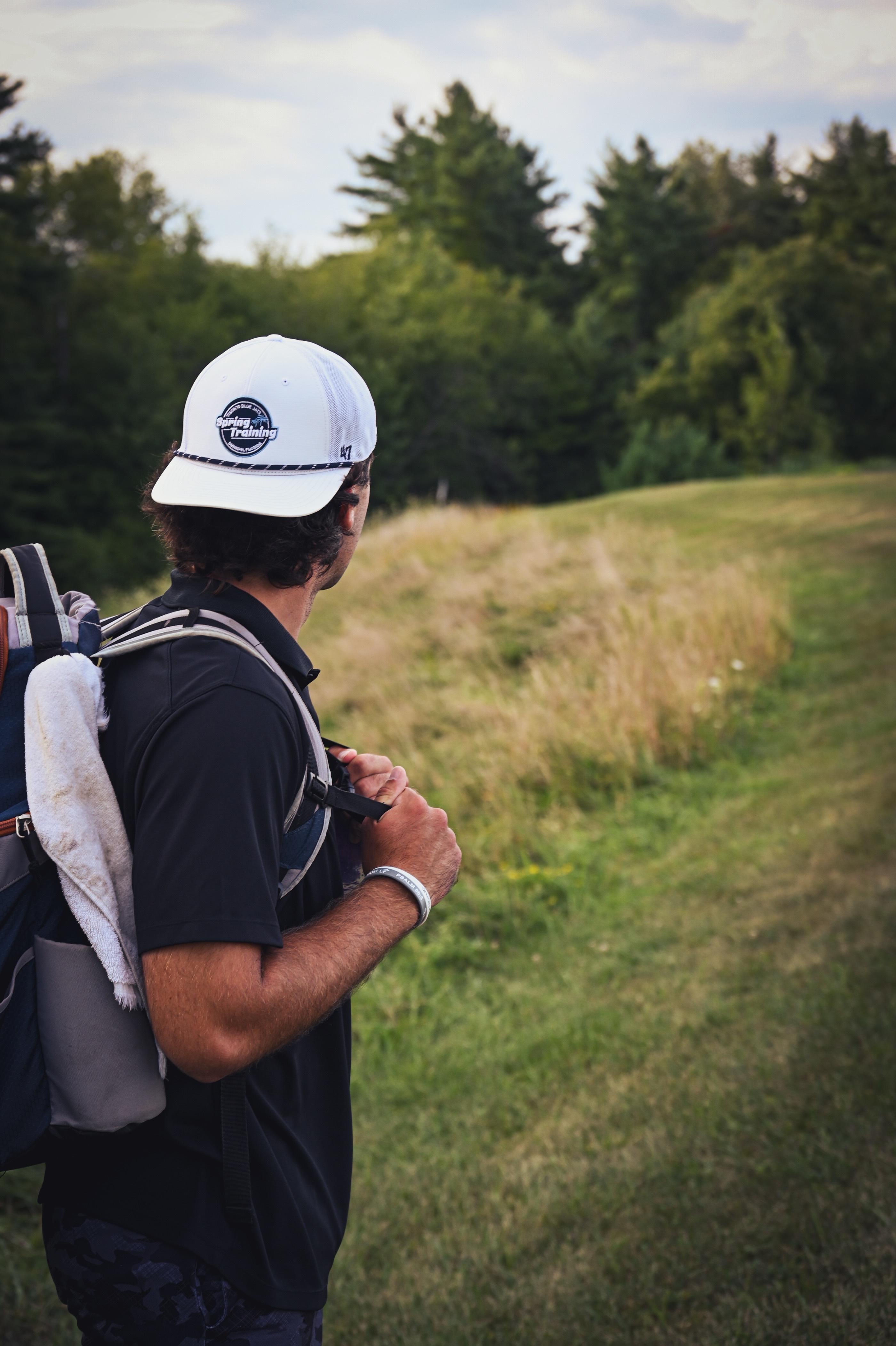 A player, bag on, looking down an unmapped fairway